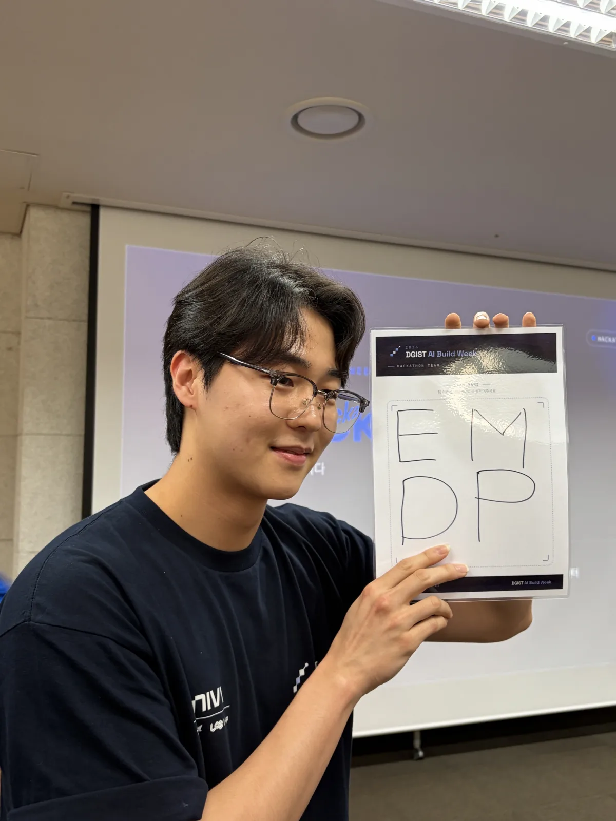 EMDP team member holding the team logo at DGIST AI Build Week